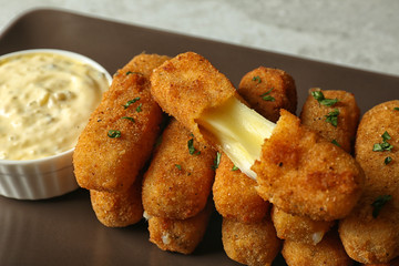 Plate with cheese sticks and sauce, closeup