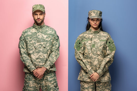 Man And Woman In Military Uniform Looking At Camera On Blue And Pink