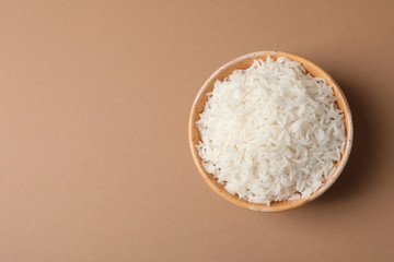 Bowl of tasty cooked rice on color background, top view. Space for text