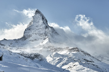 Outstanding  view of Matterhorn covered by clouds with strong wind