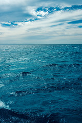 minimalistic seascape, blue sea and sky with white clouds on the whole frame