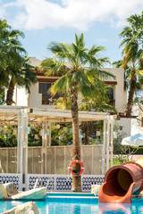 Sharm el-Sheikh, Egypt, 02/25/2019. The interior of the hotel for recreation. Swimming pool with blue water, palm trees, sun beds and water park tube