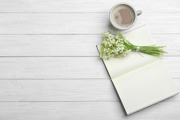 Fototapeta na wymiar Flat lay composition with notebook, lily of the valley bouquet and coffee on white wooden background. Space for text