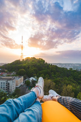couple laying and enjoying view of sunset over the city