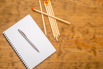 White note pad with steel pen on a wooden table. Copy space.
