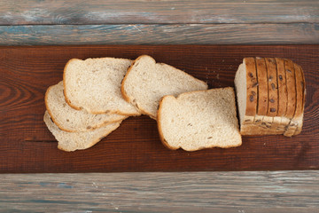 Many mixed breads and rolls of baked bread on wooden table background. Top view