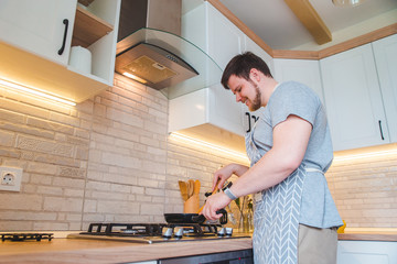 man frying on pan at the kitchen. cooking concept