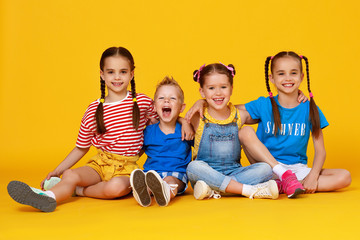 group of cheerful happy children on colored yellow background.