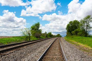 Fototapeta premium Train tracks through the Illinois countryside on a beautiful Spring afternoon.
