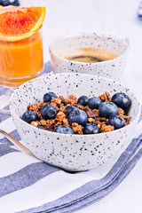 Breakfast on a white background. Fragrant coffee, orange juice and muesli with berries.