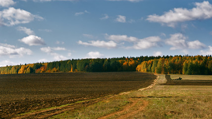 Fototapeta premium The tractor in the field plows the earth, Mari El, Russia