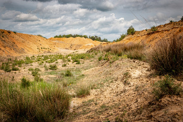 Wüste Landschaft in einer Sandgrube mit schweren Wolken