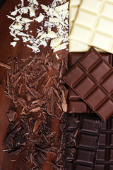 chocolate in diffrent color. milk, dark and white chocolate bars on table
