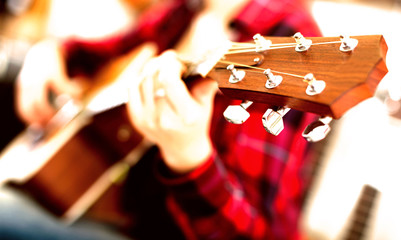 girl is playing guitar. Focus on the head of guitar