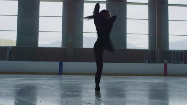 Woman practicing figure skating on ice skating rink / Murray, Utah, United States