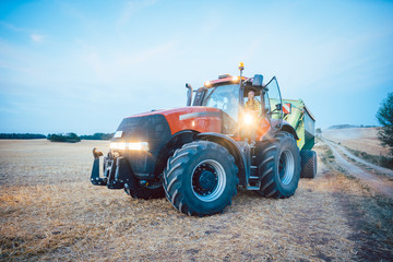 Traktor und Landmaschinen auf abgeerntetem Feld