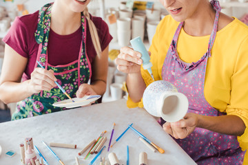 Zwei Frauen bemalen ihr eigenes Geschirr in einem Hobby Workshop 