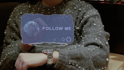 Unrecognizable woman working with HUD hologram of a smart watch with text Follow me. Female hands with future holographic technology in wrist watches - Powered by Adobe