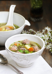 soup with meatballs in a white bowl. light soup with pork meatballs.
