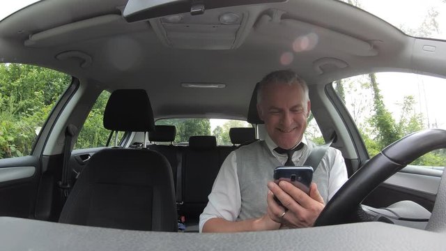 People, travel and communication technology. Man with mobile telephone, driver with cell phone driving car on the street, using smartphone for text messaging and internet. Danger and risk on the road