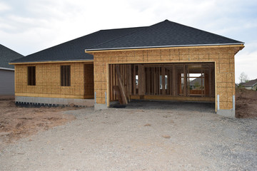 Fototapeta na wymiar New Home Under Construction with Lumber Framing and Carpentry Builders Craftsman
