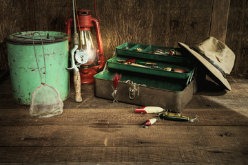Vintage fishing equipment and lantern on grungy wood surface