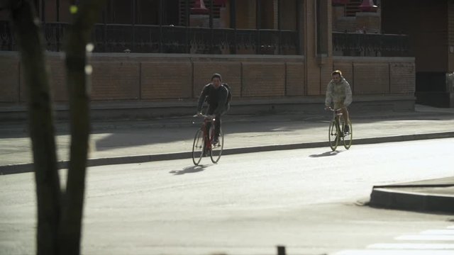 Male cyclists ride bicycles at city street. Ecological urban transport concept. Active lifestyle. Urban environment without car traffic.