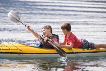 Brothers and friends enjoying their summer vacation in a kayak