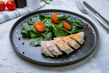 chicken fillet with spinach on black plate
