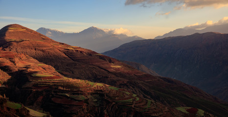 Fototapeta na wymiar Dongchuan Red Earth Multi-Colored Terraces - Red Soil, Green Grass, Layered Terraces in Yunnan Province, China. Chinese Countryside, Agriculture, Exotic Unique Landscape. Farmland, Agriculture