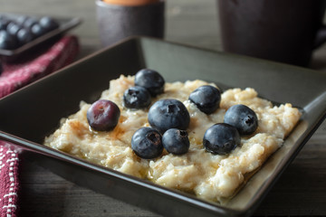 Breakfast Serving of Oatmeal with Bluberries, Coffee and Egg on a Vintage Table