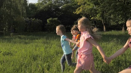Many different kids running in the park on sunny summer day in casual clothes