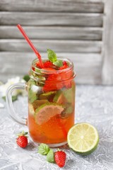 Mojito lemonade with strawberries on a dark background in a trendy mug pot.