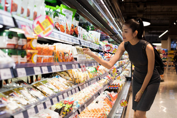 Mother Asian Working woman select pick up healthy nutrition food, yogurt milk from supermarket...