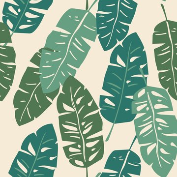 All over seamless repeat pattern with green tropical banana palm leaves on a cream background