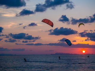 Silhouette people kitesurfing sunset clouds. Koh Phangan. Thailand