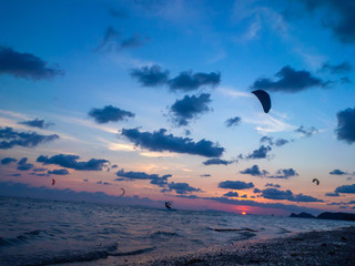 Silhouette people kitesurfing sunset clouds. Koh Phangan. Thailand