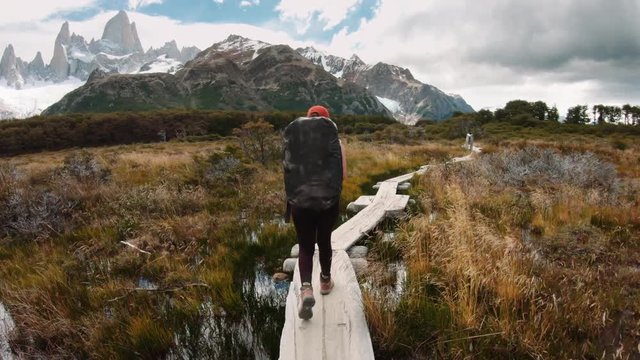 Female mountaineer walking on a wooden trail towards the campsite of the Fitz Roy mount. 4k