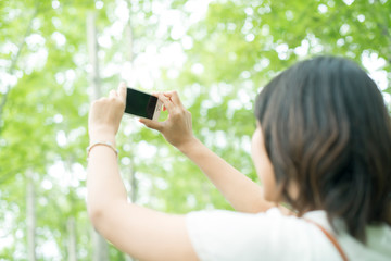 スマートフォンで写真を撮る女性