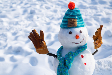Handmade snowman in the snow outdoor. Christmas snowman on white snow background. Merry Christmas...