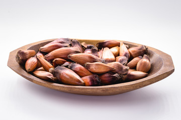 Brazilian pine in brown wooden rustic bowl. Typical araucaria tree seed used as a condiment in Brazilian cuisine in winter.