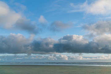 Fototapeta na wymiar White Clouds and Blue Skies Along Ocean