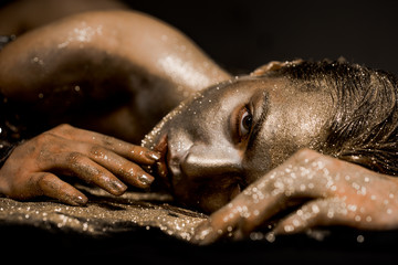 Pure gold. Golden lady relaxing. Vogue and glamour concept. Golden skin. Sexy girl face makeup body art metallized color - Gold concept. Golden skin. Golden mask. Luxury beauty procedure