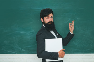 Professor in class on blackboard background. Chalkboard copy space. Teachers day.