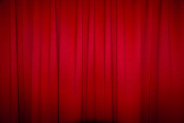 Red closed curtain with a light spo