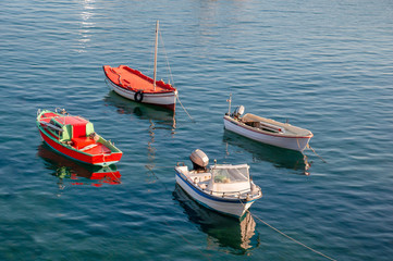 Naklejka na ściany i meble Four different fishing boats anchored in a bay