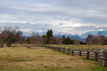 Mountain wooden fence with snow-capped mountains