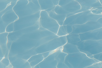 Blue pool water with sun reflections