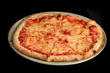 top view of whole sliced cheese pizza on round white plate