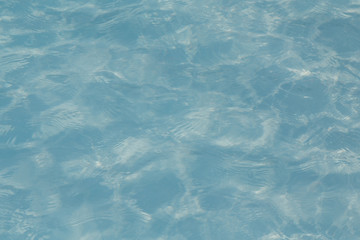 Blue pool water with sun reflections